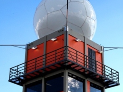 Tall red and gray tower with a large white spherical radar dome on top, marked with the CEMIG logo, under a clear sky.
