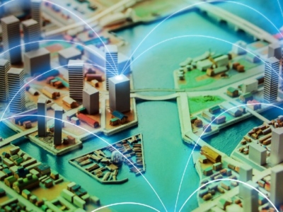 Detailed miniature model of a modern city with buildings, waterways, and glowing blue arcs symbolizing digital connectivity.