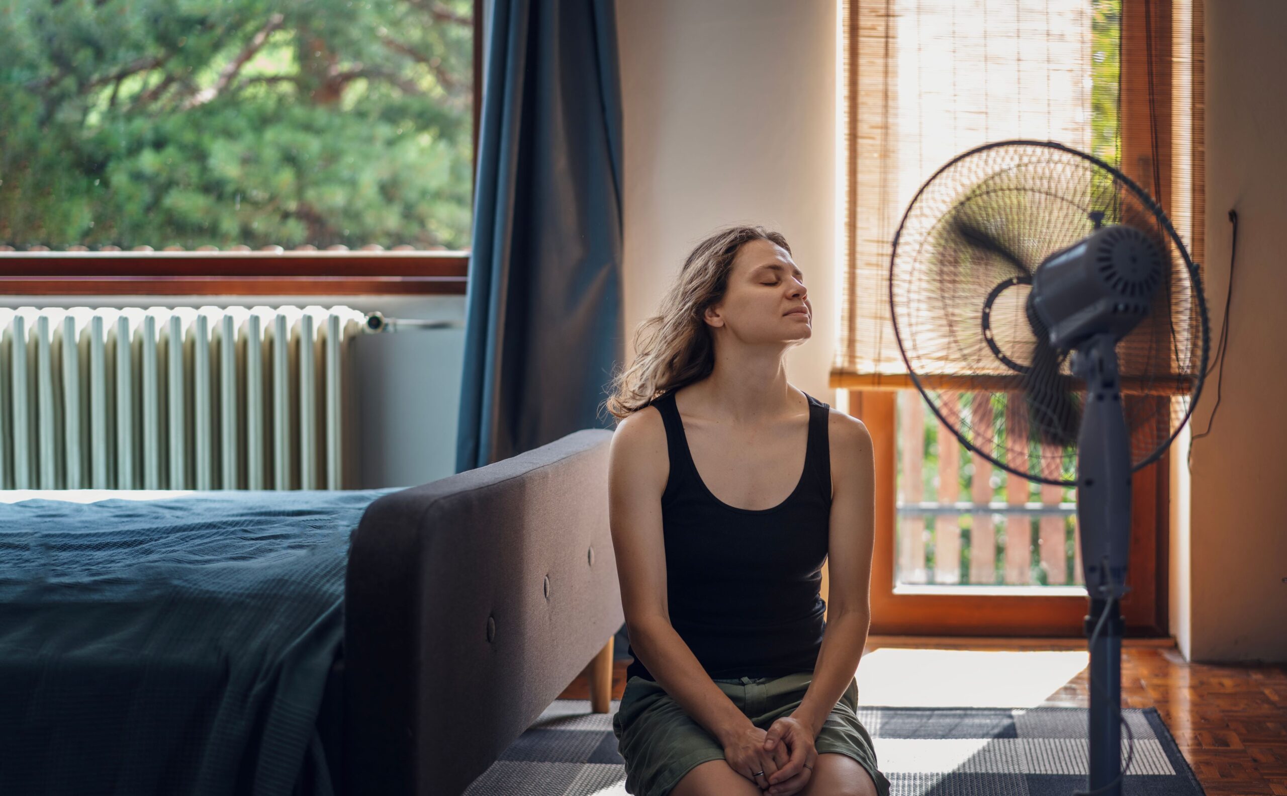 Imagem de uma mulher refrecando-se em frente a um ventilador