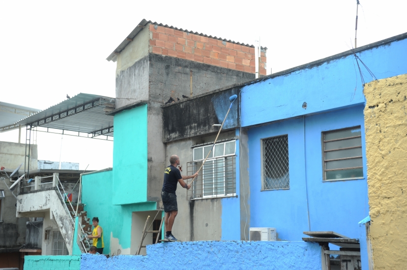 Imagem de um homem pintando uma casa