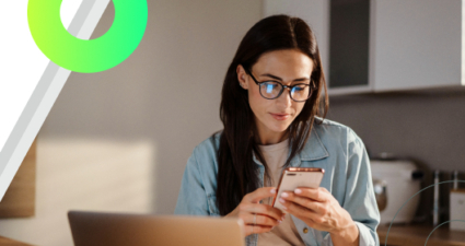 Banner com fundo branco à esquerda e, no lado direito, uma mulher jovem de óculos e camisa jeans usando o celular em frente a um notebook. A composição inclui grafismos abstratos, como um anel verde neon e formas geométricas nas bordas e sobre a mesa